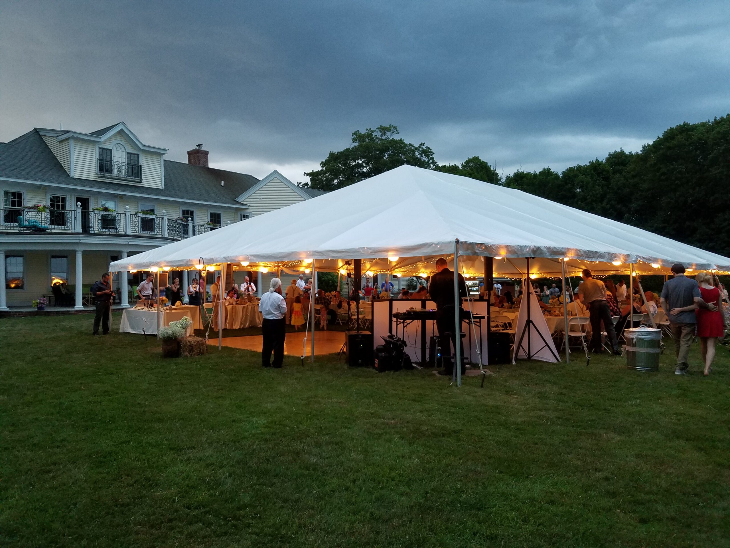 White tent with a dance floor and people around it